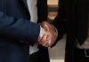 Împăcarea publică dintre Trump și Michael Cohen: semnificații politice și implicații Business partners shake hands, making a deal