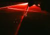 Red laser beams cutting through darkness