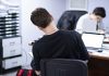 a man sitting at a desk in front of a laptop computer