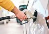 a man pumping gas into his car at a gas station