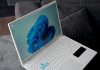 A white laptop with a blue windows 11 wallpaper