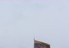 The lithuanian flag flies atop a brick tower